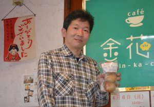 自慢のベーグルを持つ戸澤さん