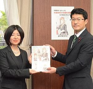 マンガを受け取る阿部議長（右）