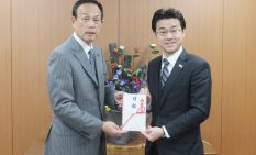 目録を手渡す田中社長（右）